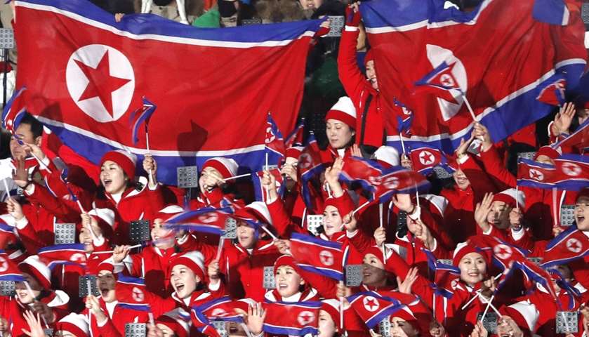 Cheerleaders of North Korea wave their national flags as they wait the start of the opening ceremony