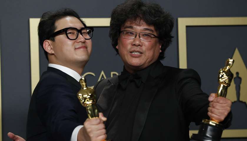 Han Jin Won and Bong Joon Ho pose with the Oscar for Best Original Screenplay for \"Parasite\"