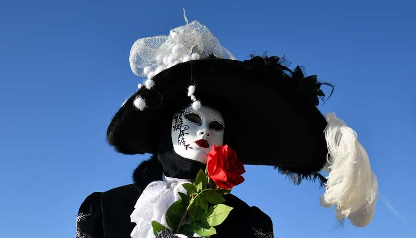 A reveller wearing a mask and a period costume takes part in the Carnival 
