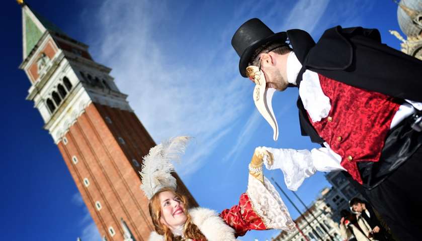 Revellers wearing a mask and a period costume take part in the Venice Carnival

