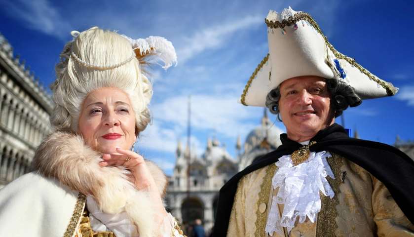 Revellers wearing a mask and a period costume take part in the Carnival 
