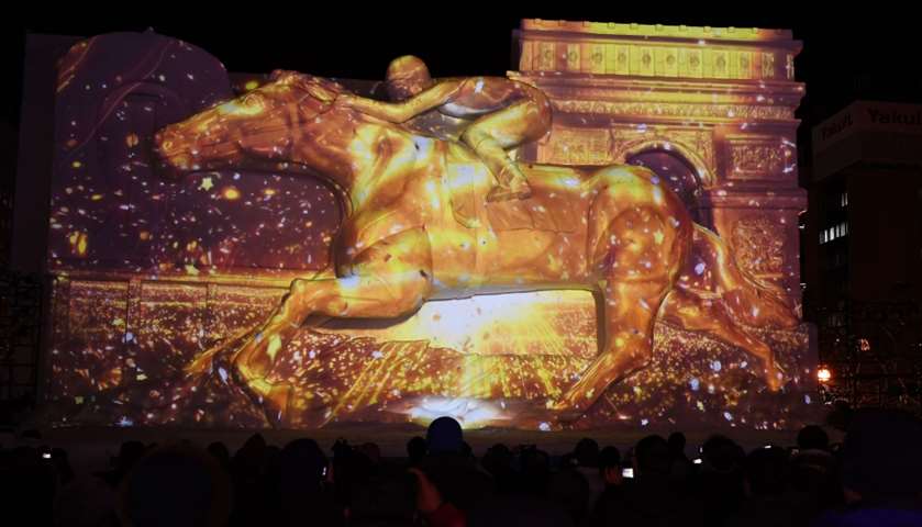 A giant snow sculpture representing the Prix de l\'Arc de Triomphe, a horse race

