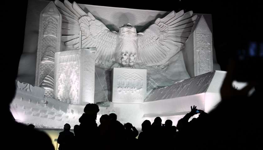 A giant snow sculpture representing a Blakiston\'s fish owl seen after sundown 

