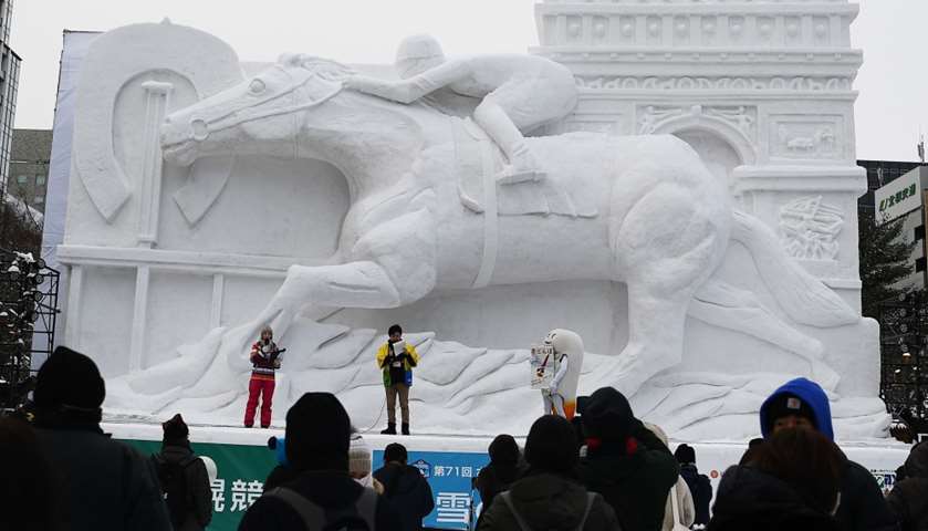 A giant snow sculpture representing the Prix de l\'Arc de Triomphe, a horse race held in Paris
