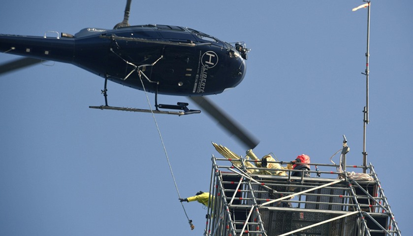 Helicopter lifts the statue of Archangel Michael from top of Mont Saint-Michel Abbey for maintenance