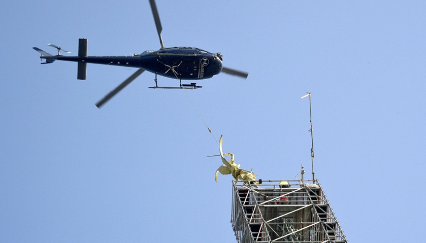 Helicopter lifts the statue of Archangel Michael from top of Mont Saint-Michel Abbey for maintenance