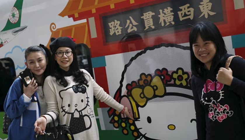 Hello Kitty fans pose in front of a Taroko Express train in Taipei 
