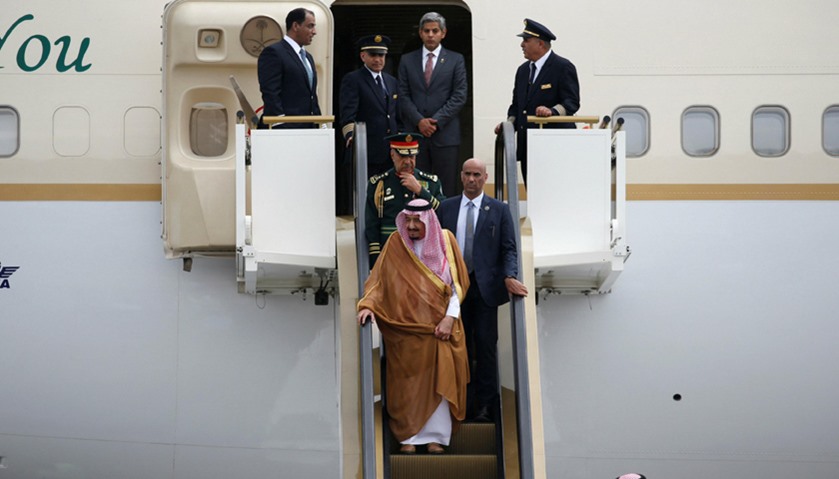 Saudi King stands on an escalator as he arrives at the International Airport in Jakarta