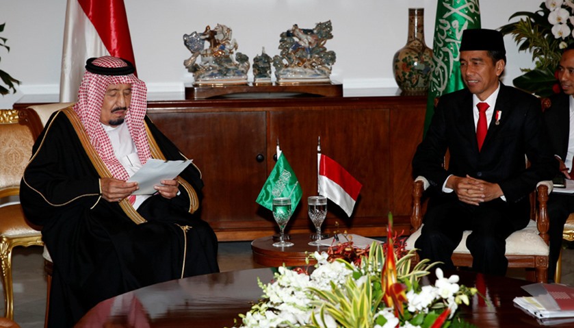 Saudi Arabia\'s King Salman reads documents as Indonesian President Joko Widodo looks on