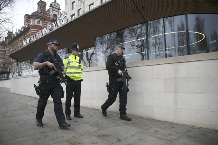 Armed police officers patrol outside New Scotland Yard in London on Thursday