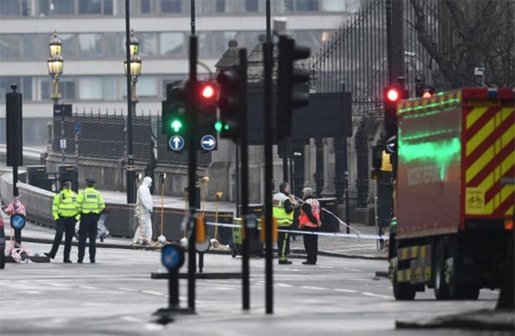 Forensic officers work at the scene of the attack by the Houses of Parliament in London