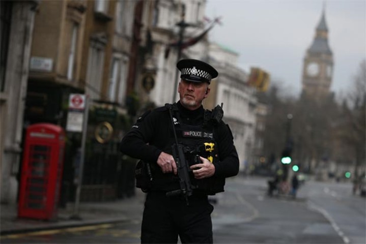 An armed police officer stands on Whitehall the morning after an attack in London