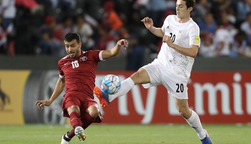 Iran\'s forward Sardar Azmoun (R) vies for the ball against Qatar\'s forward Hasan al-Haydos
