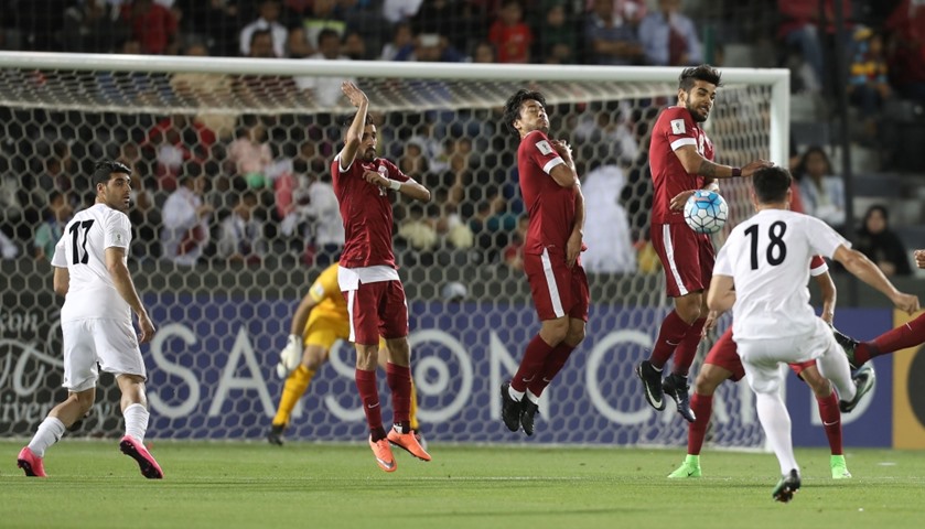 Iran\'s forward Alireza Jahan Bakhsh (R)takes a free kick