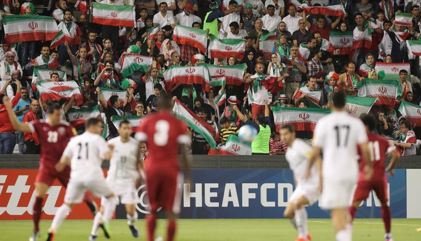 Iranian fans wave their national flag as they cheer