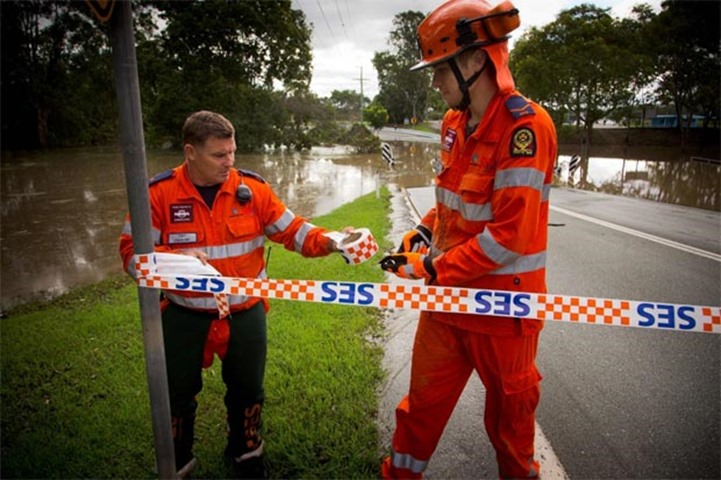 A State Emergency Service crew closes a flooded road in Beenleigh on Friday