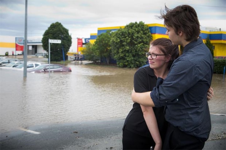 Maddie Skyring is comforted by a companion after discovering her submerged car