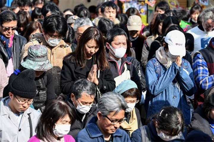 A one-minute silence is observed for victims of the 2011 tsunami and earthquake at a park in Tokyo