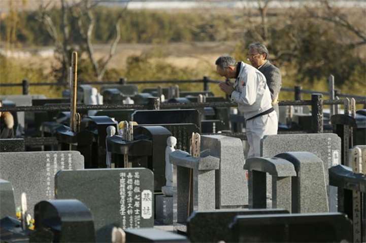 Relatives pray at a cemetery for victims of the 2011 Great East Japan earthquake in Namie, Fukushima