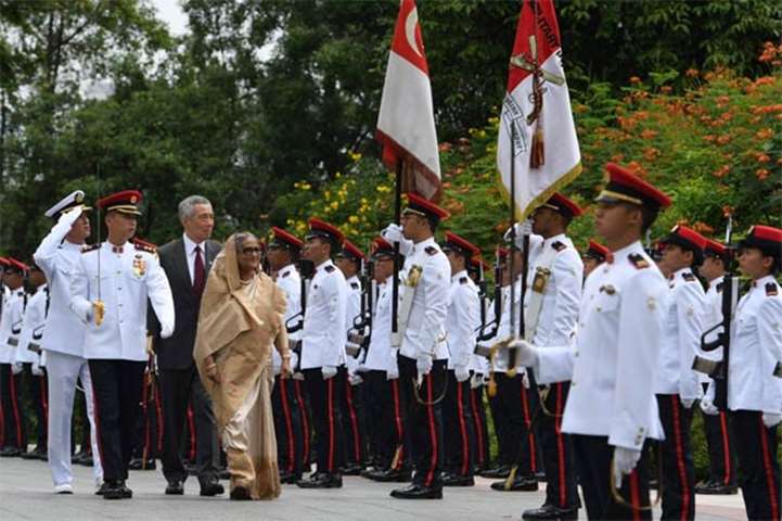 Sheikh Hasina inspects a guard of honour while attending a welcoming ceremony in Singapore