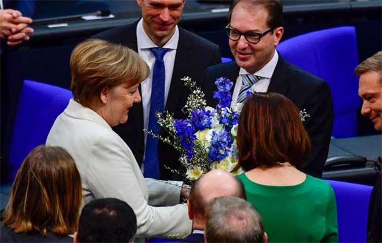 Angela Merkel is offered flowers after she was re-elected on Wednesday