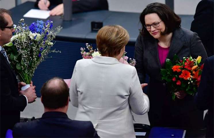 Angela Merkel is congratulated by Andrea Nahles, designated leader of the social democratic party