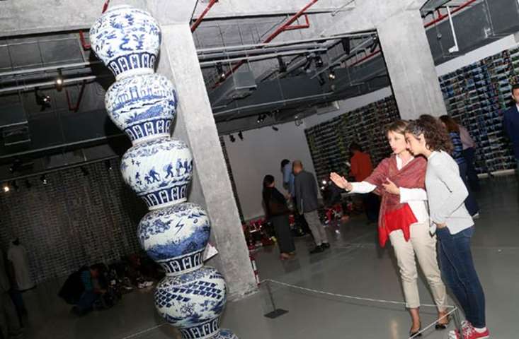 \'Stacked Porcelain Vases as a Pillar\' represents themes of the refugee condition