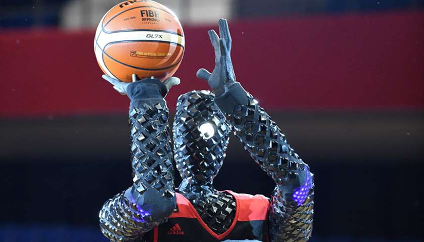 The basketball-playing robot named CUE prepares to shoot the ball during a show rehearsal