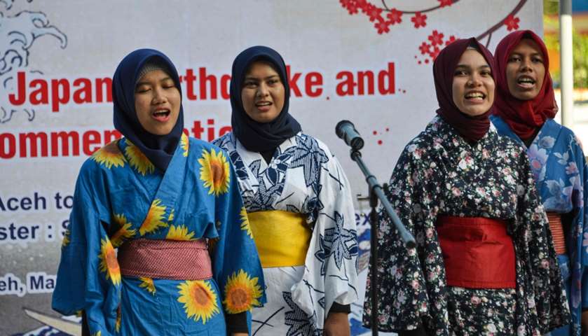 Indonesian students dressed in kimonos sing as they take part in the remembrance event