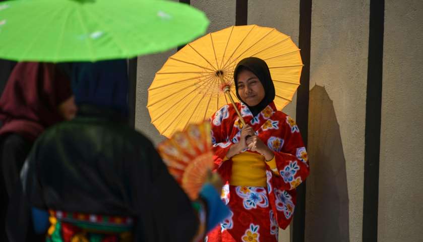Indonesian students dressed in kimonos take photos as they take part in the remembrance event