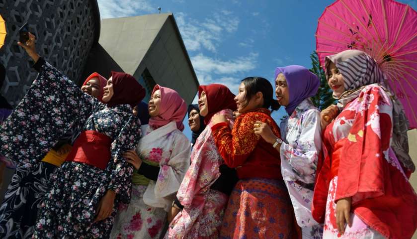 Indonesian students dressed in kimonos take selfies as they take part in the remembrance event