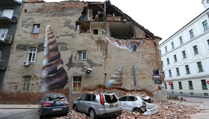 Damaged cars and a partially damaged building are seen following an earthquake, in Zagreb, Croatia