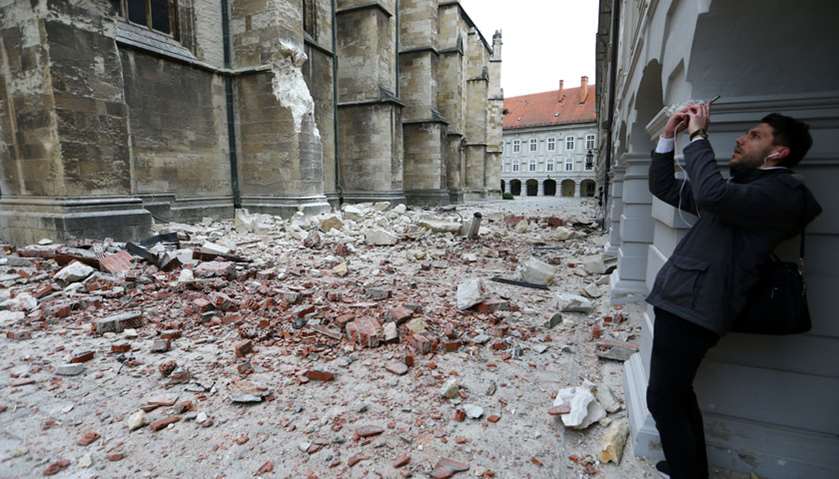 A man takes pictures of damages outside the cathedral of Zagreb after an earthquake, in Zagreb, Croa