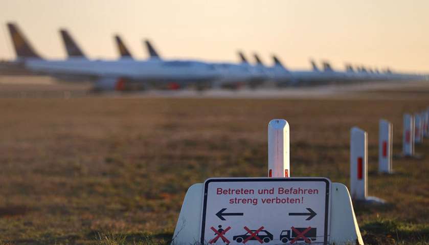 Planes of the German carrier Lufthansa are parked behind a sign reading: \"crossing strictly forbidde