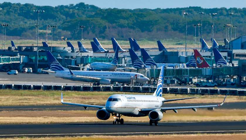 A Copa airlines plane taxis on a runway as others sit on the tarmac at Tocumen International Airport