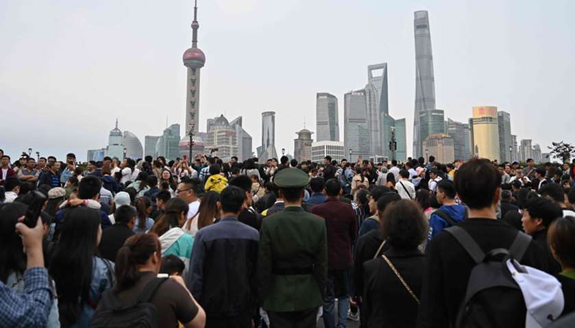 People visiting the promenade on the Bund along the Huangpu River in Shanghai