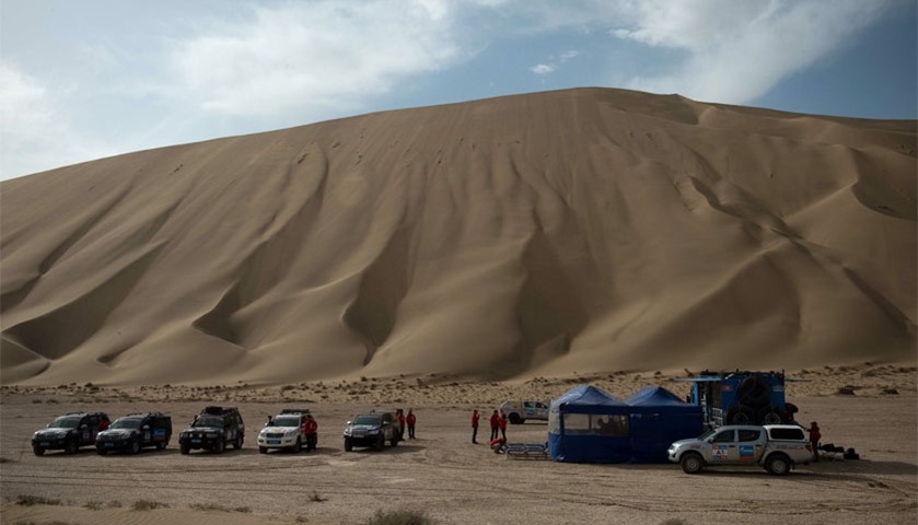 Vehicles are parked by a temporary camp during an off-road mapping recognition excercise