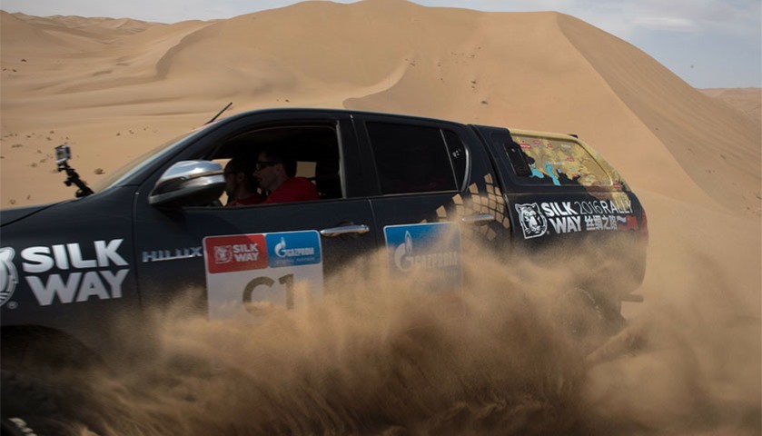 French former overall Ski World Cup winner Luc Alphand drives his car over sand dunes