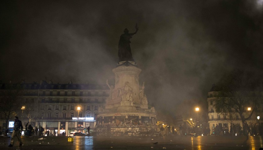 Tear gas lobbed by French gendarmes fills the night sky at the Place de la République following clas