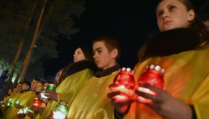 Ukrainians hold candles in front of the monument to Chernobyl victims in Slavutich