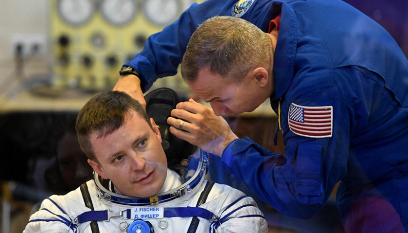 NASA astronaut Jack David Fischer (L) has his spacesuit tested at the Russian-leased Baikonur cosmod