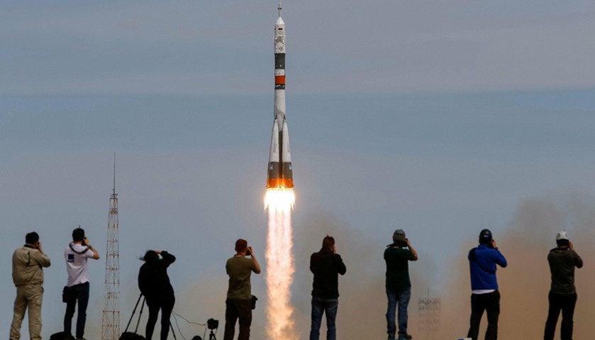Photographers take pictures as the Soyuz MS-04 spacecraft carrying the crew blasts off to the ISS