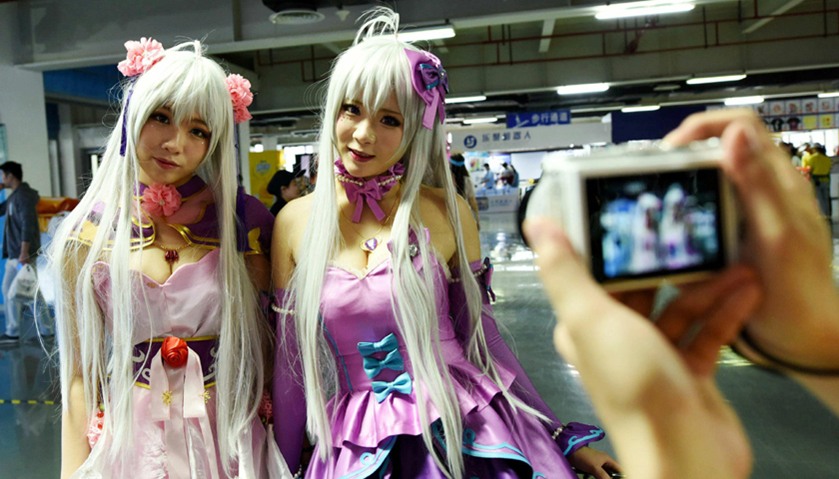 two cosplay fans posing for photos as they attend the China International Cartoon and Animation Fest