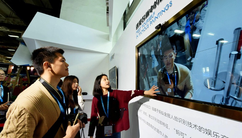 a man (L) trying a face recognition product as he visits the China International Cartoon and Animati