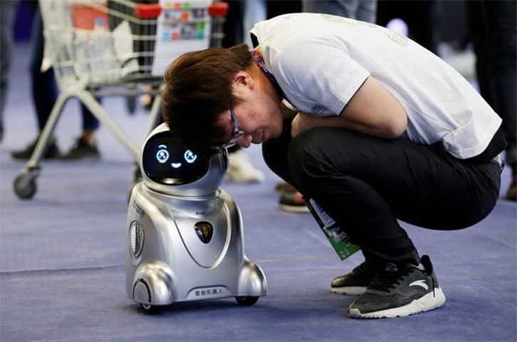 A visitor listens to a YYD robot at GMIC