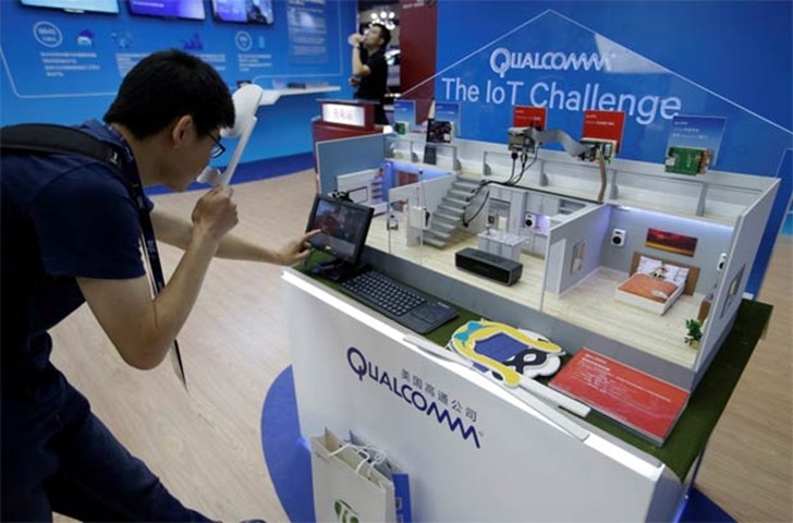 A man views Qualcomm\'s products at its booth at GMIC