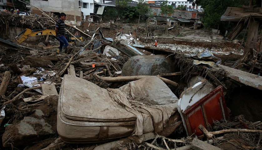A man looks at a destroyed area, after flooding and mudslides caused by heavy rains