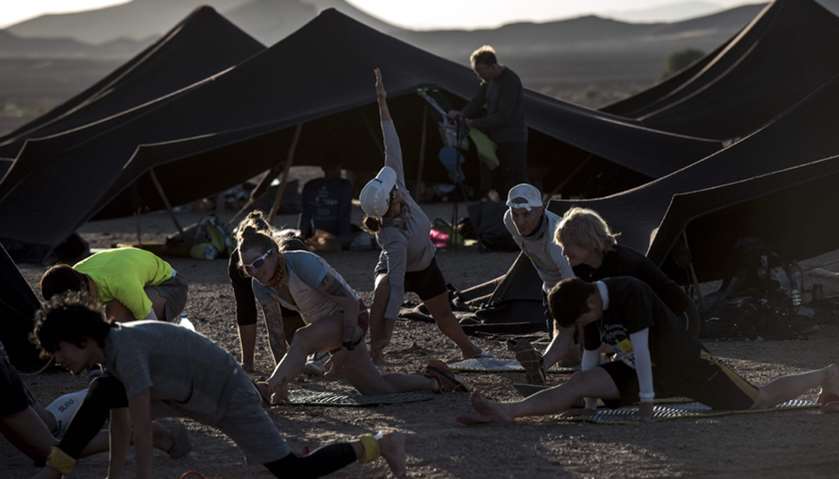 Competitors stretch at the bivouac after stage 1 of the 33rd edition of the Marathon
