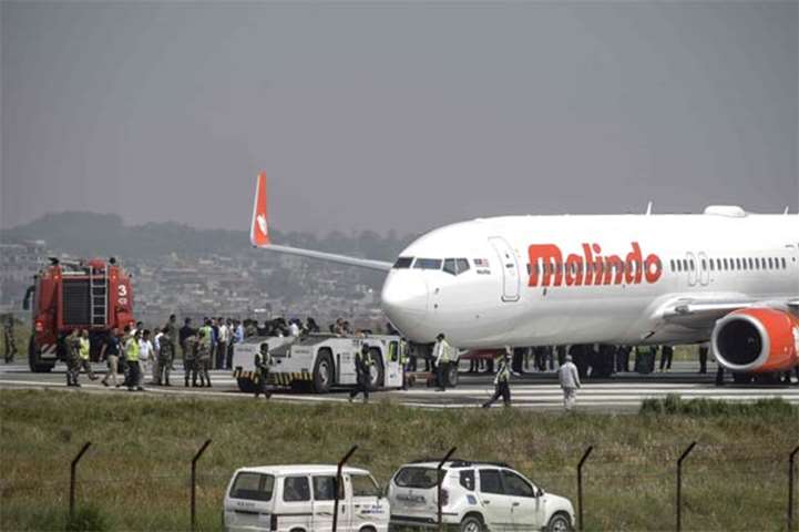 Nepali workers try to bring a Malaysian airliner back onto the runway in Kathmandu on Friday