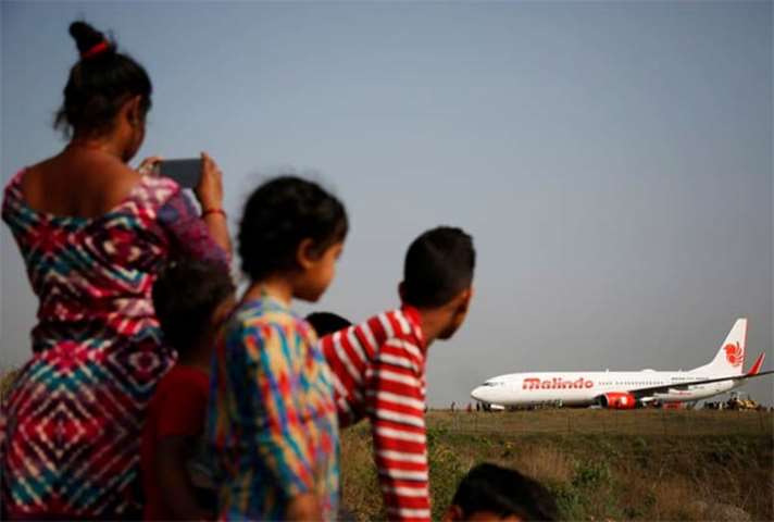 People look at an aircraft belonging to Malindo Air that skidded off the runway in Kathmandu